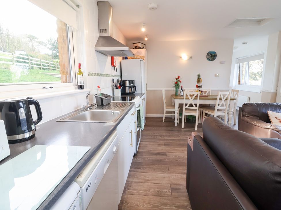 A kitchen with a dining area and seating at Castle View Lodge in Ilfracombe
