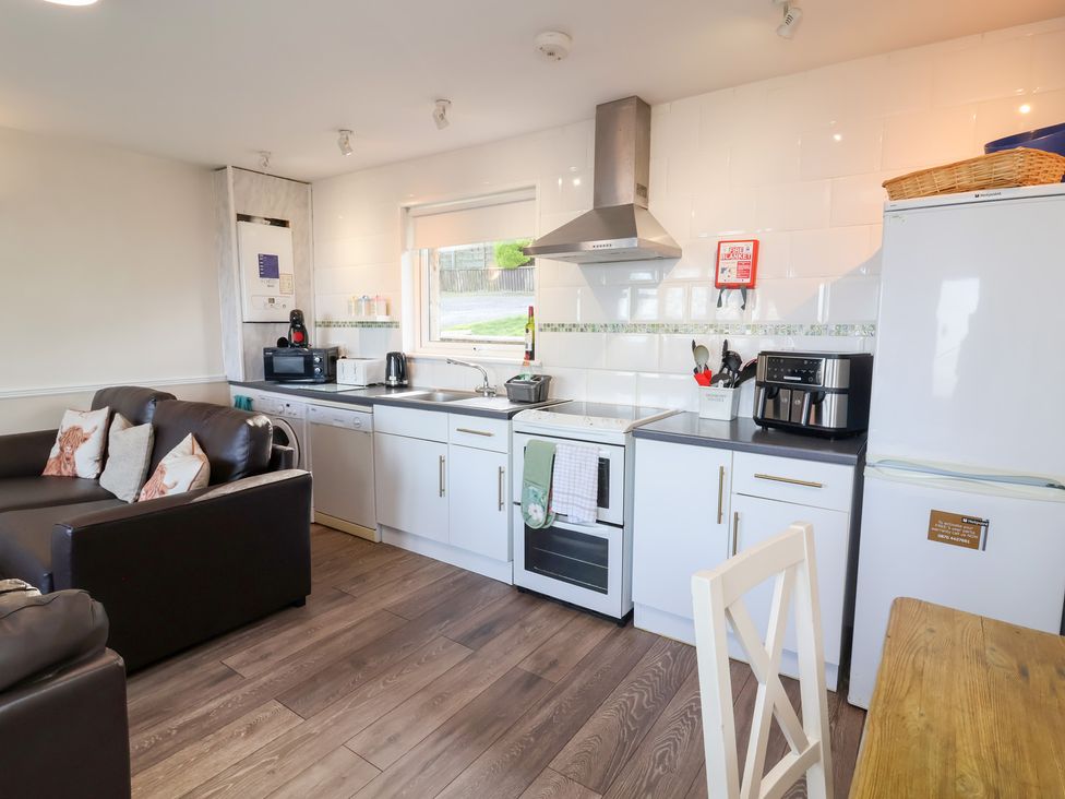 A kitchen with appliances and seating at Castle View Lodge in Ilfracombe