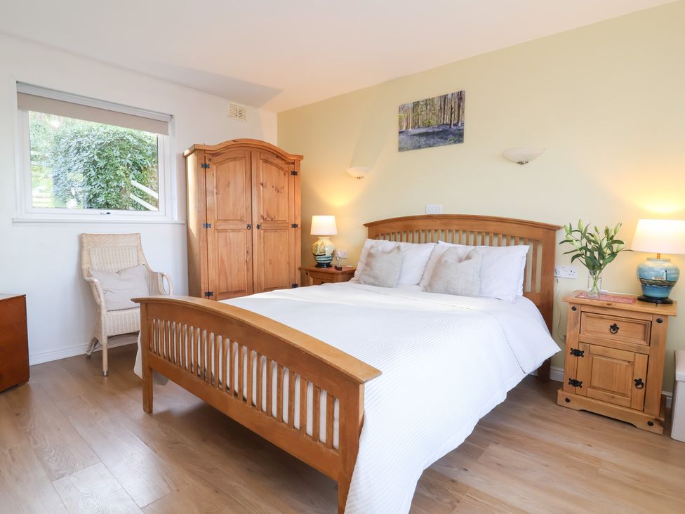 A bedroom with a bed and wooden furniture at Castle View Lodge in Ilfracombe