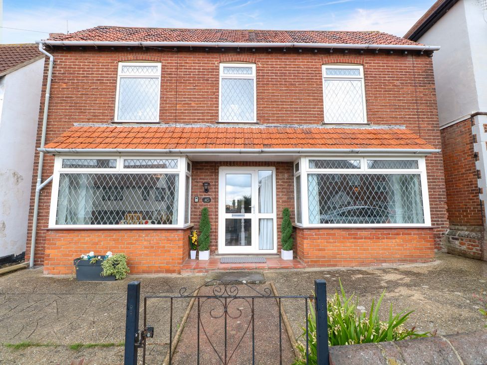A brick house with windows and a front door at Highland House in Sheringham