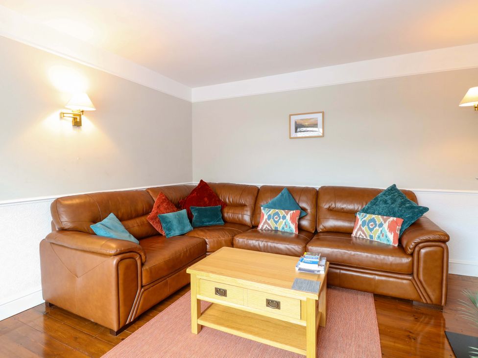 A living room with a sofa and coffee table at Highland House in Sheringham