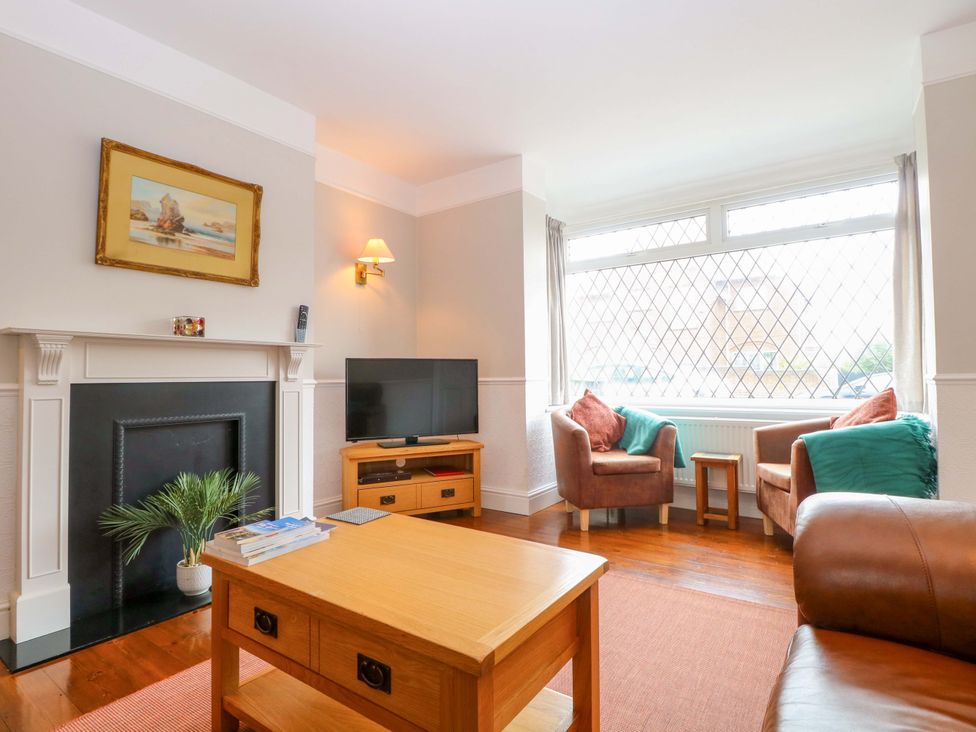 A living room with a sofa and coffee table at Highland House in Sheringham