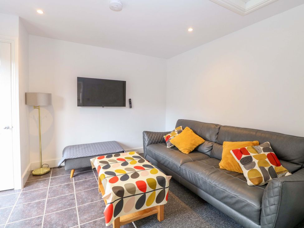 A living room with a sofa and coffee table at Highland House in Sheringham
