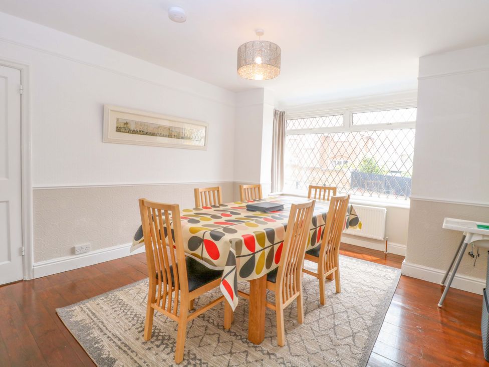 A dining room with a table and chairs at Highland House in Sheringham