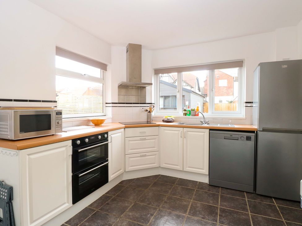 A kitchen with appliances and a window at Highland House in Sheringham
