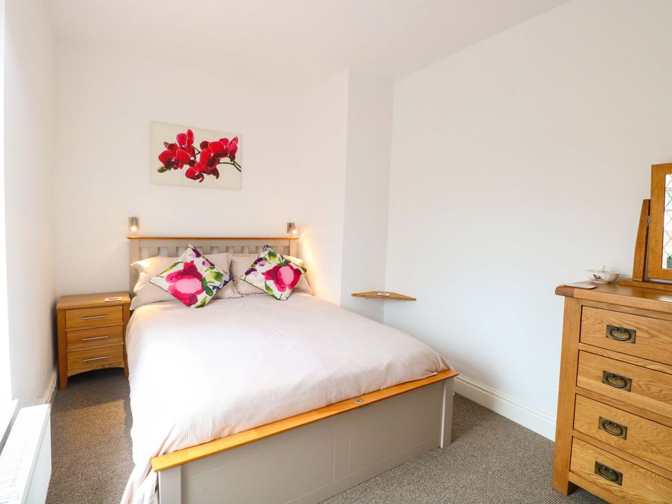 A bedroom with a bed and nightstand at Highland House in Sheringham