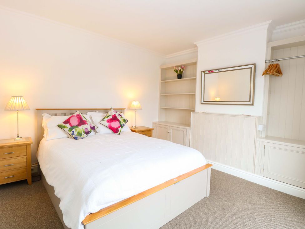 A bedroom with a bed and lamps at Highland House in Sheringham