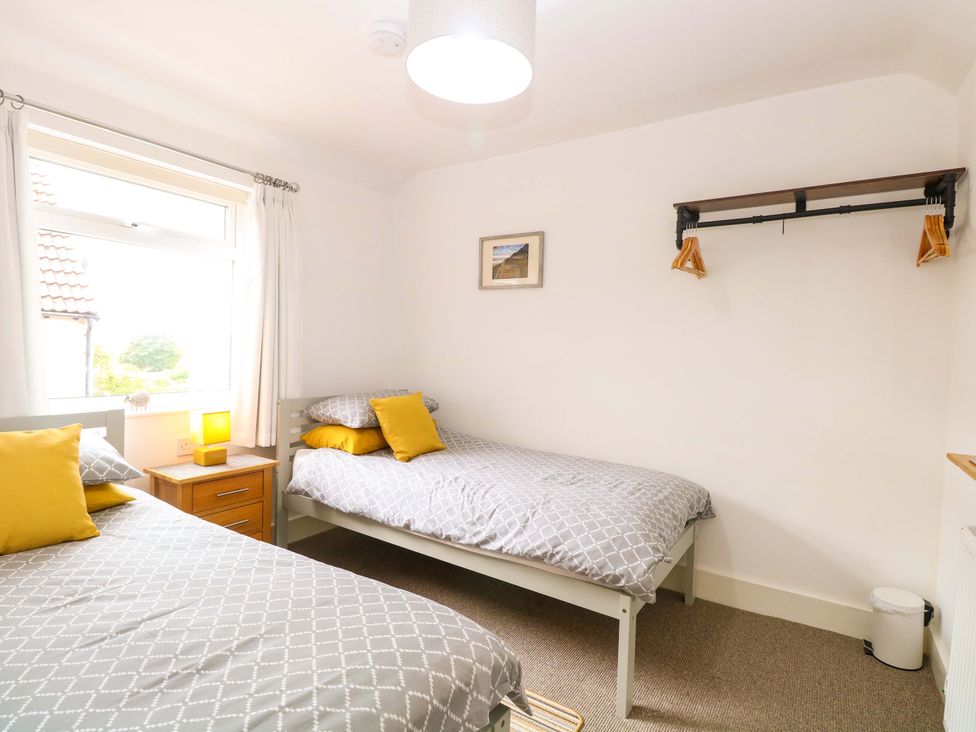 A bedroom with two beds and a window at Highland House in Sheringham