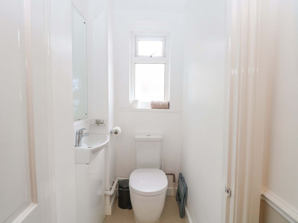 A bathroom featuring a toilet and sink at Highland House in Sheringham