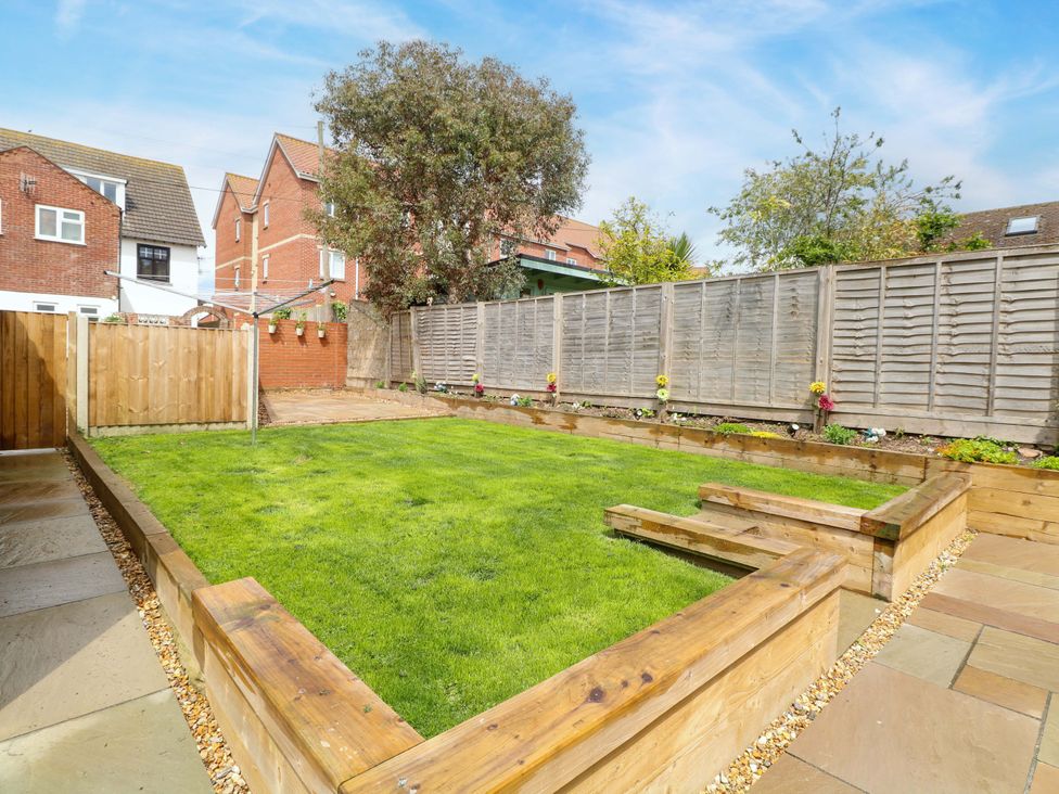 A garden with grass and wooden borders at Highland House, Sheringham
