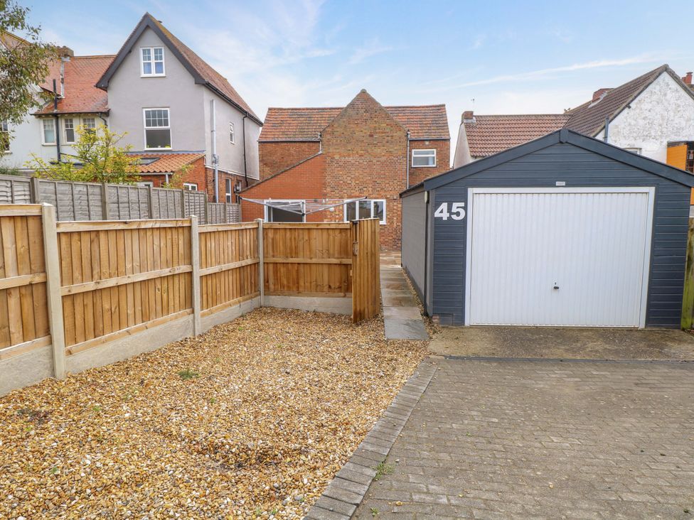 An outdoor area with a garage and pathway at Highland House in Sheringham