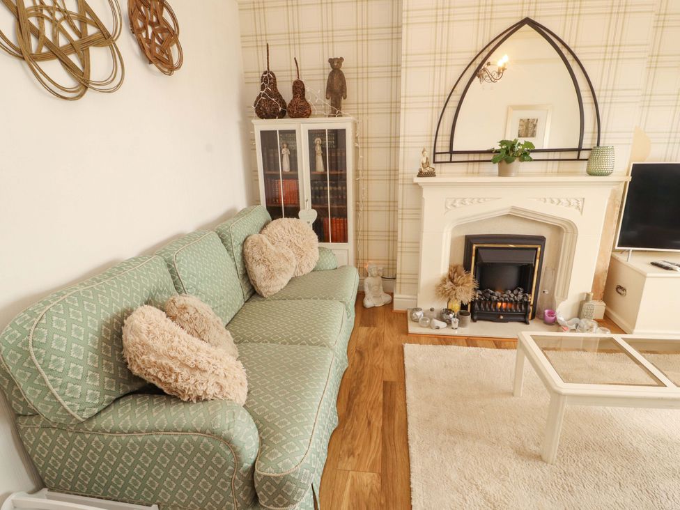 A living room with a sofa and fireplace at 2 The Crescent