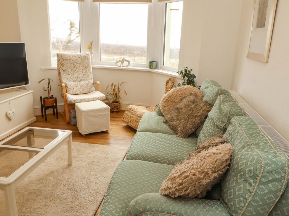 A living room with a sofa, coffee table, and television at 2 The Crescent