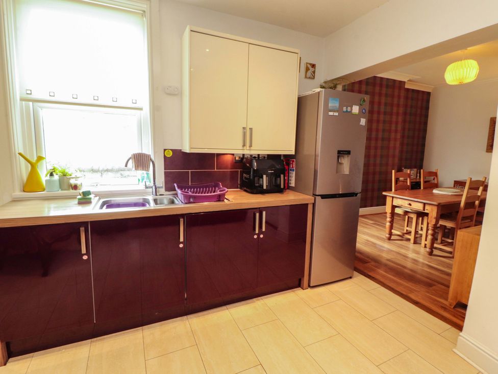 A kitchen with cabinets and a dining area at 2 The Crescent