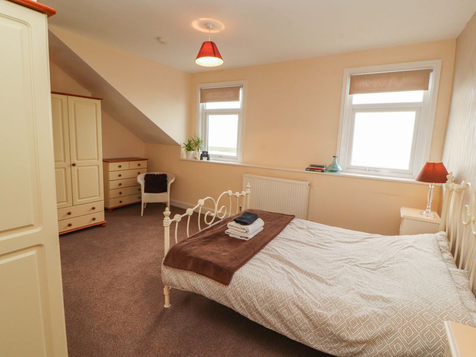 A bedroom with a bed and windows at 2 The Crescent
