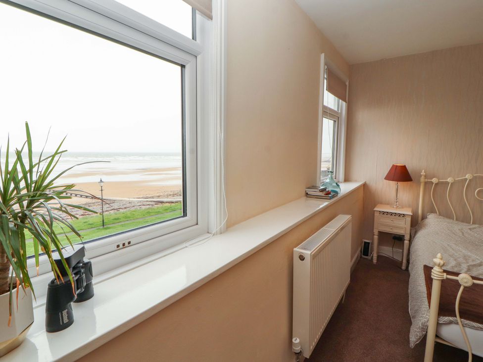 A bedroom with a view of the beach at 2 The Crescent