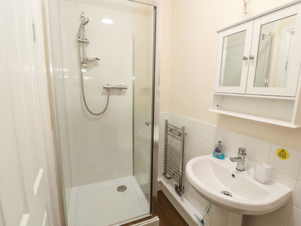 A bathroom with a shower, sink, and towel radiator at 2 The Crescent 