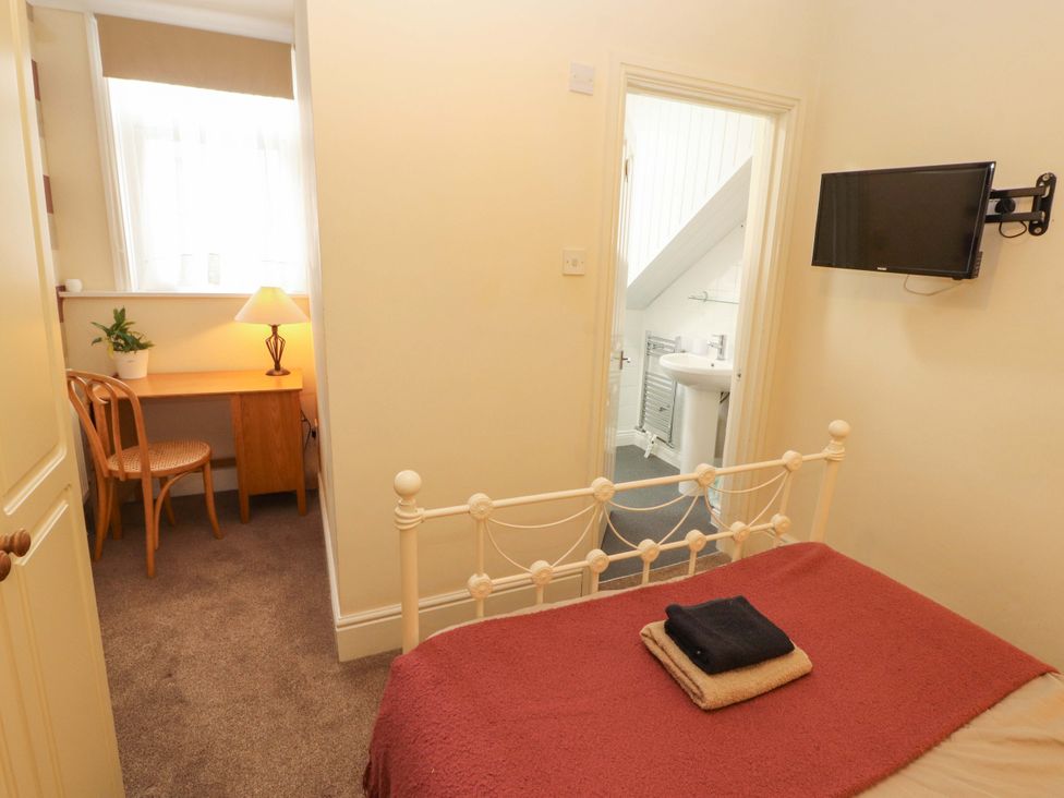 A bedroom with a bed, desk, and television at 2 The Crescent