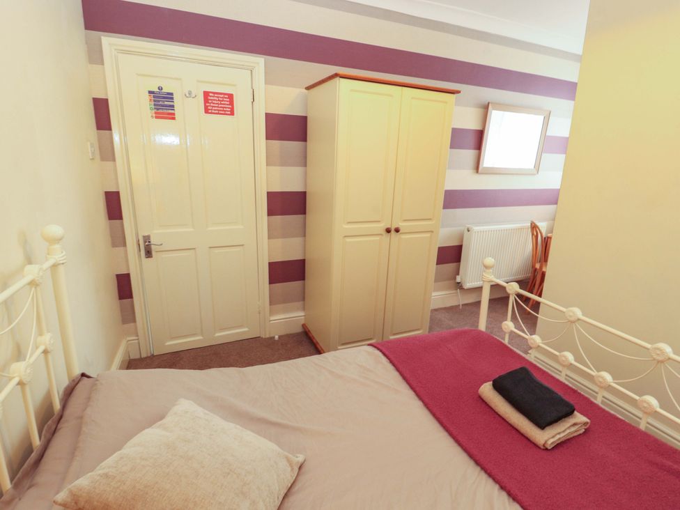 A bedroom with a bed and wardrobe at 2 The Crescent
