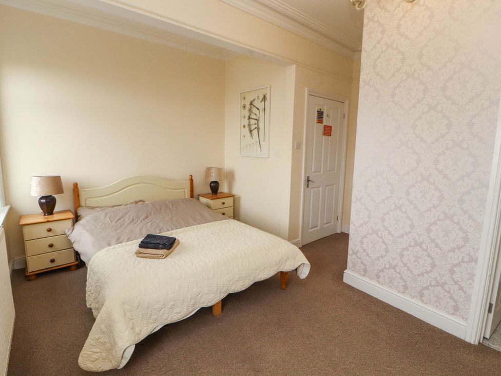 A bedroom with a bed and nightstands at 2 The Crescent