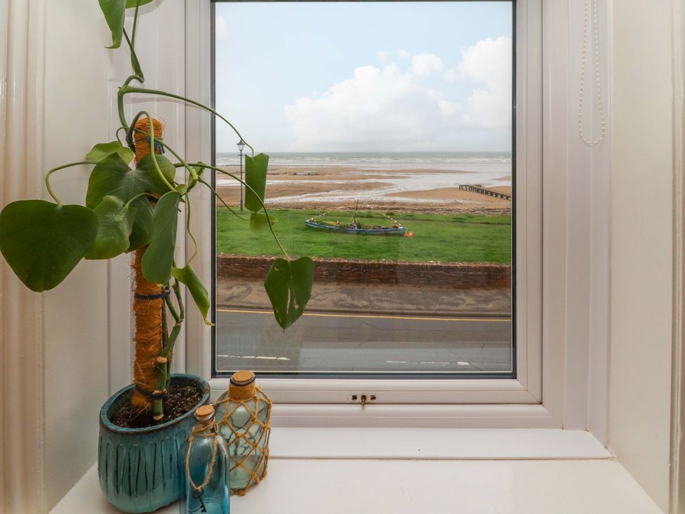 A window view with a plant and vase overlooking the sea at 2 The Crescent