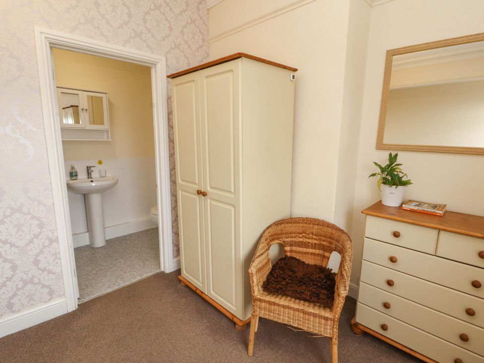 A bedroom with a wardrobe and chair at 2 The Crescent