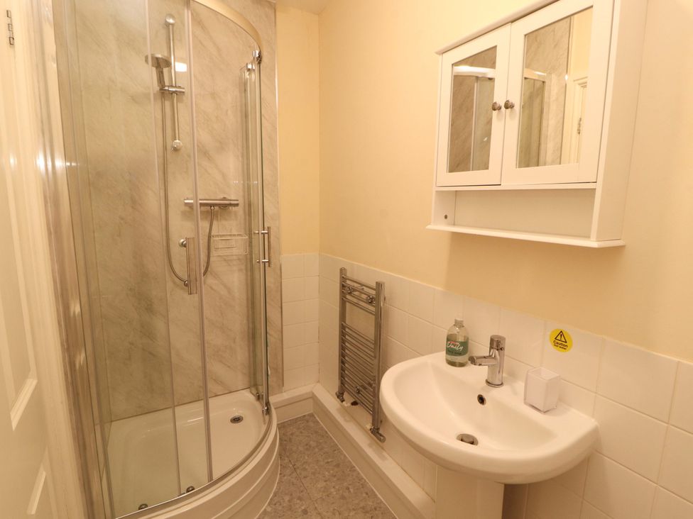 A bathroom with a shower, sink, and mirror cabinet at 2 The Crescent