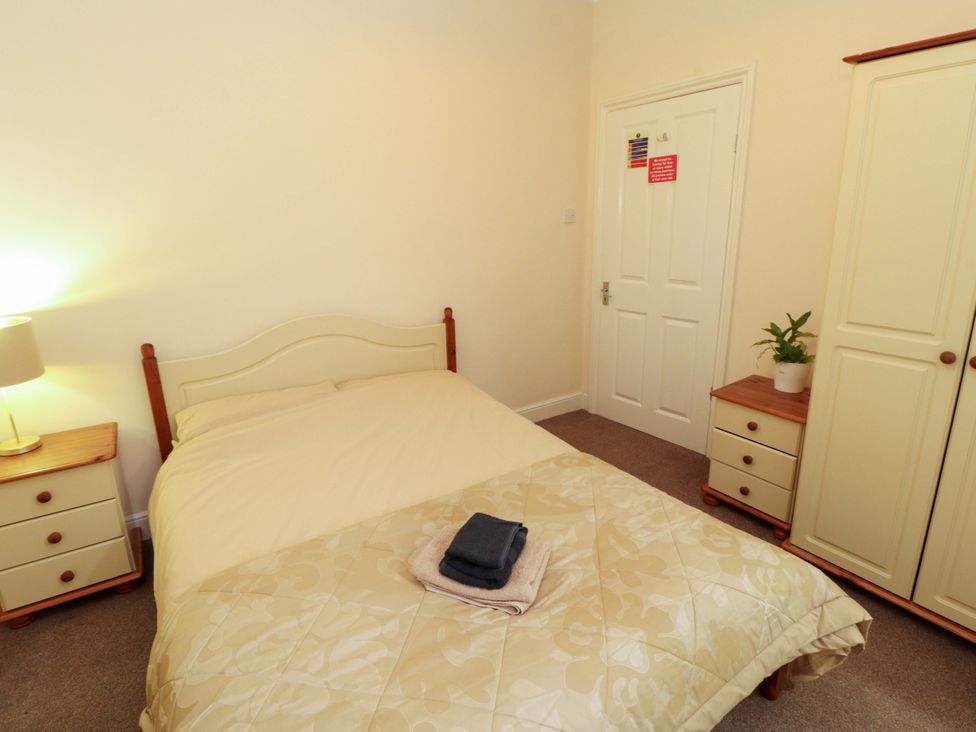 A bedroom with a bed and bedside lamp at 2 The Crescent