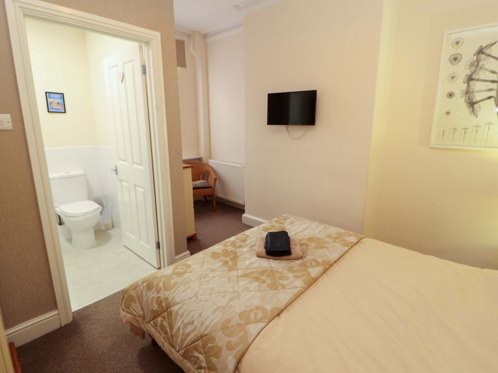 A bedroom with a bed and a door leading to a bathroom at 2 The Crescent 
