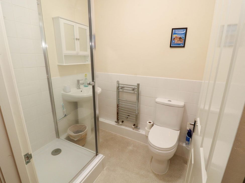 A bathroom with a shower, toilet, sink, and towel rail at 2 The Crescent