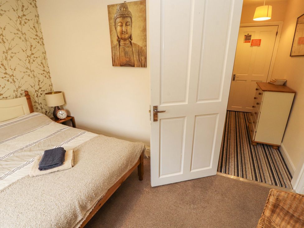 A bedroom with a bed and a door leading to another room at 2 The Crescent