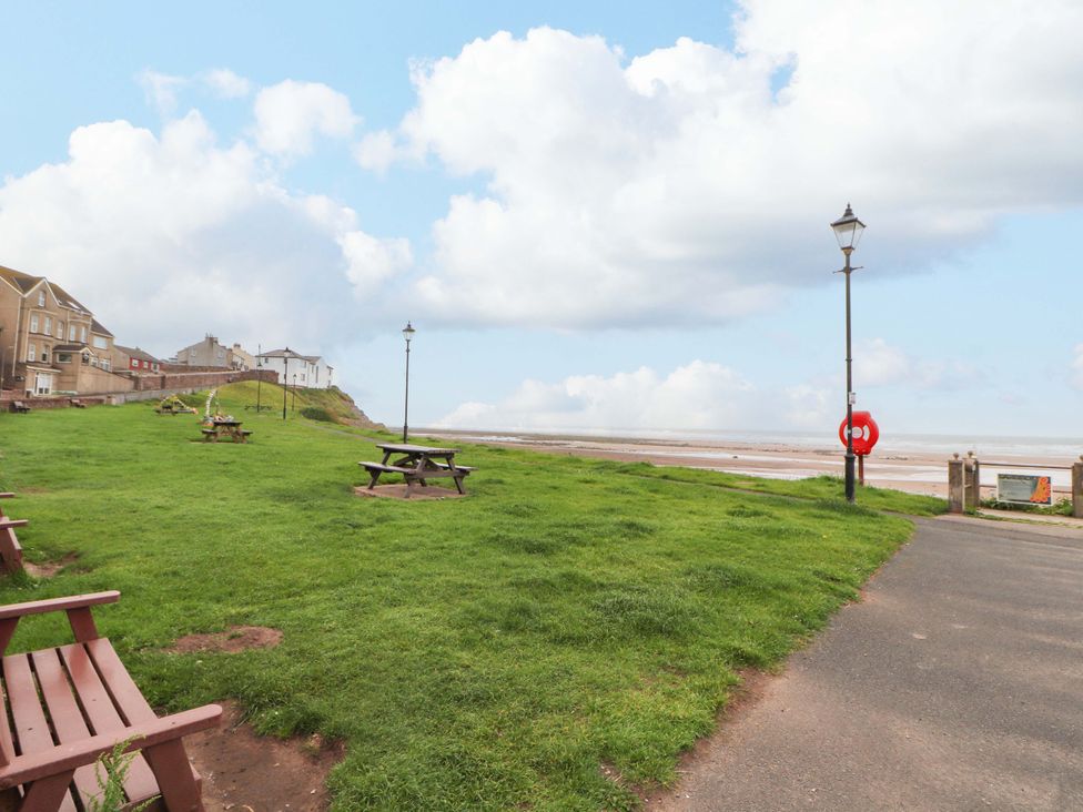 A park area with benches and a path near the coast at 2 The Crescent 