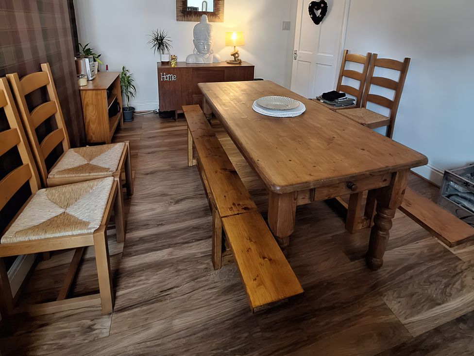 A dining room with a wooden table and chairs at 2 The Crescent Seascale