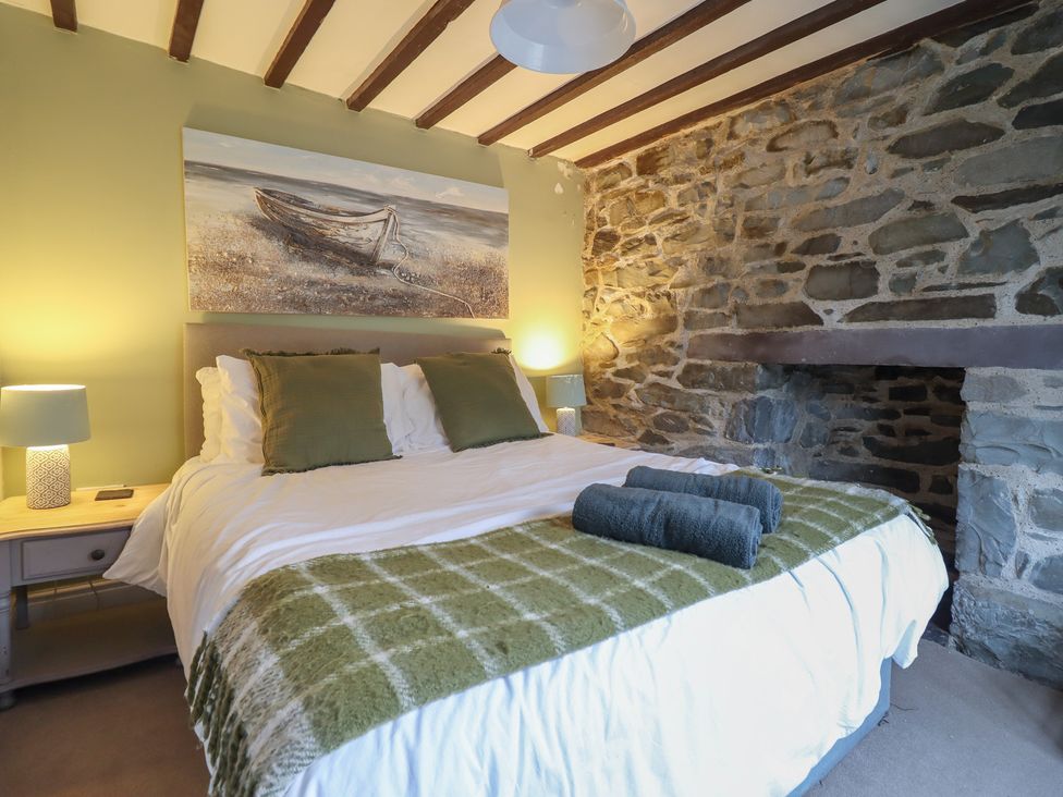 A bedroom with a bed and bedside table at Riverwash Cottage Dwygyfylchi