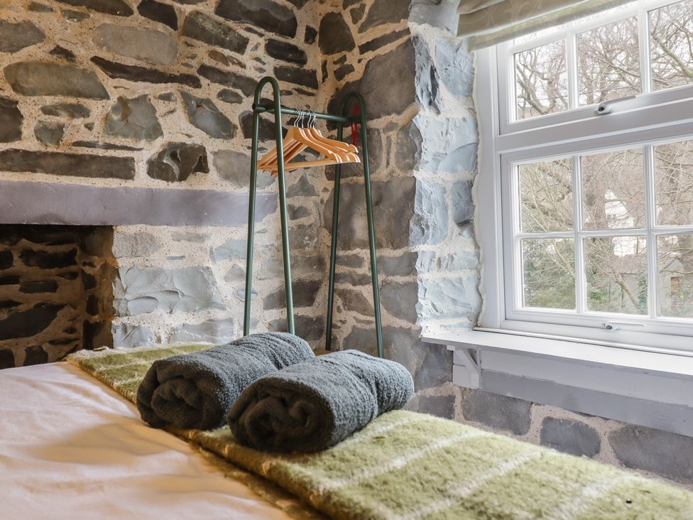A bedroom with a window and towel rack at Riverwash Cottage in Dwygyfylchi