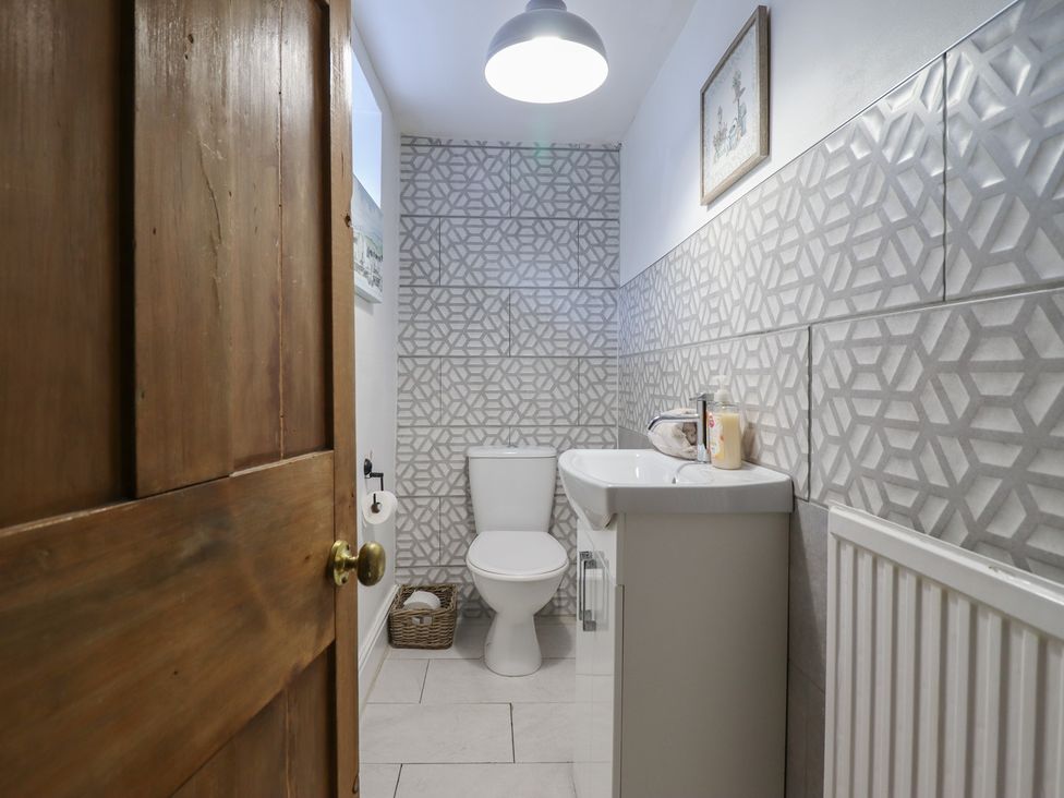A bathroom with a toilet and sink at Riverwash Cottage Dwygyfylchi