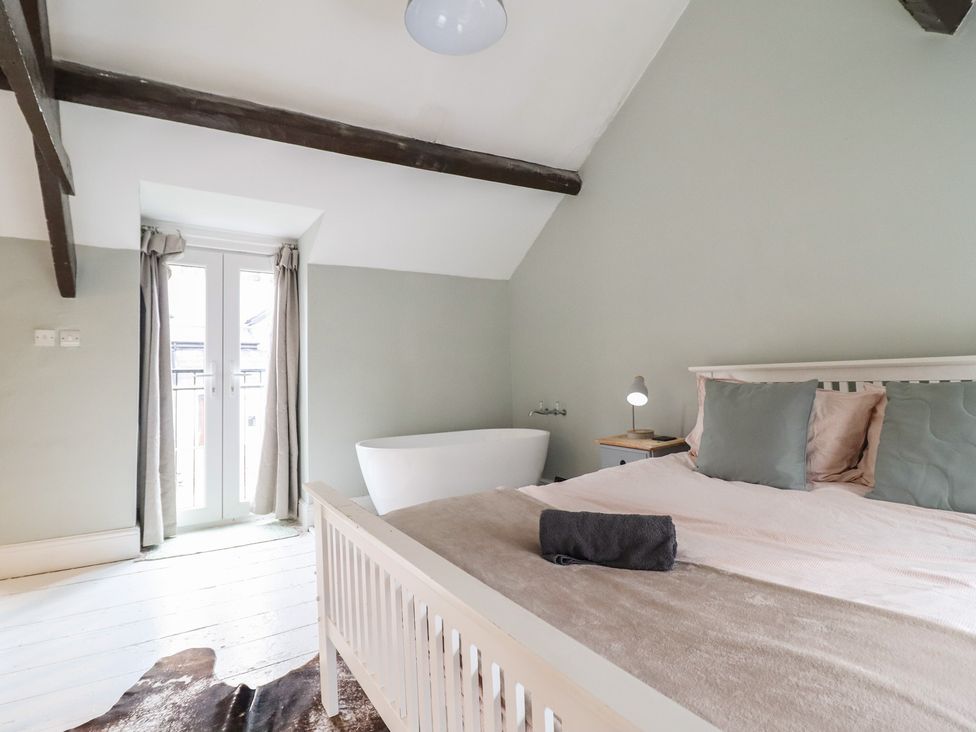 A bedroom with a bed and bathtub at Riverwash Cottage in Dwygyfylchi