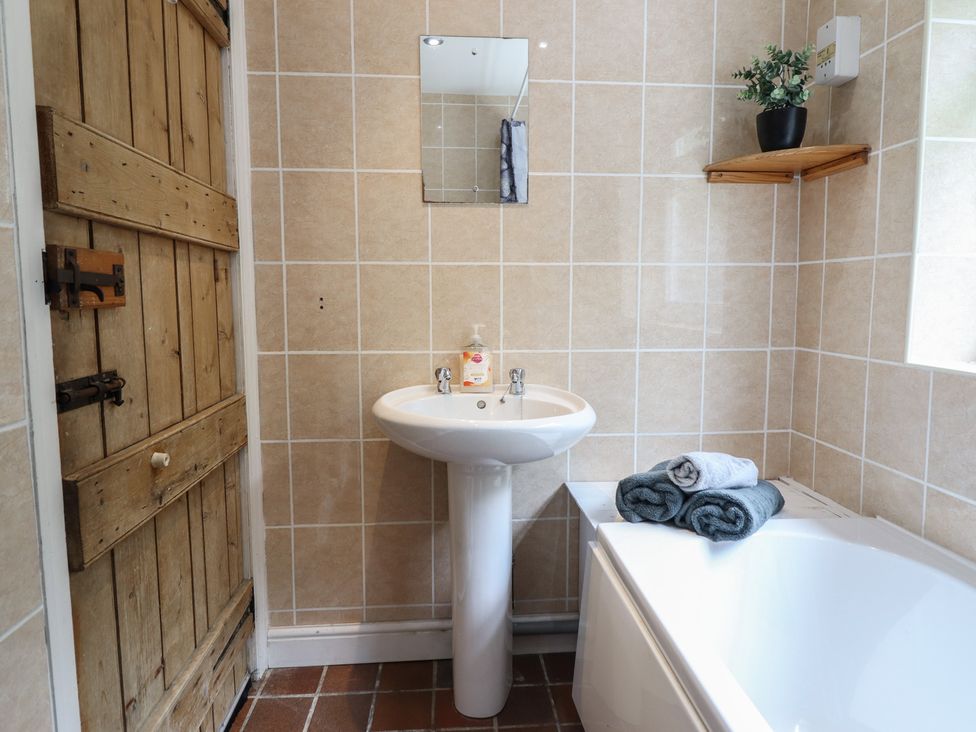 A bathroom with a sink and bath tub at Riverwash Cottage in Dwygyfylchi