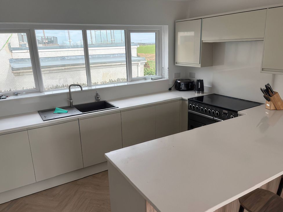 A kitchen with a sink and stove at Seaddler in Trearddur Bay