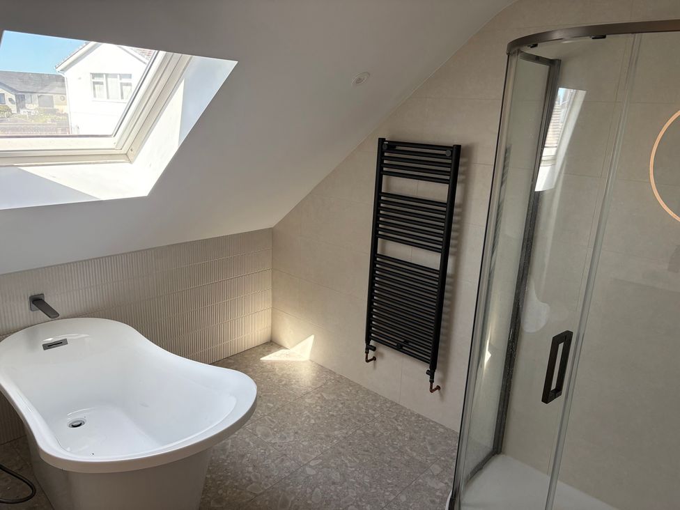 A bathroom with a bathtub and shower at Seaddler in Trearddur Bay