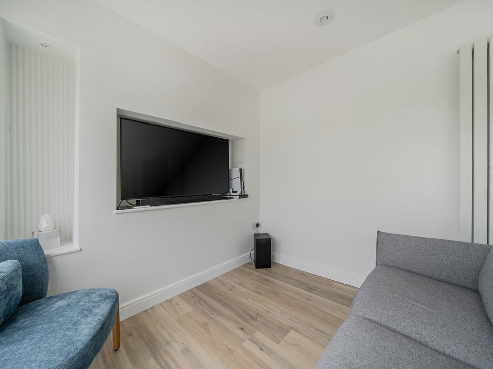 A living room with a television mounted on the wall at Seaddler in Trearddur Bay