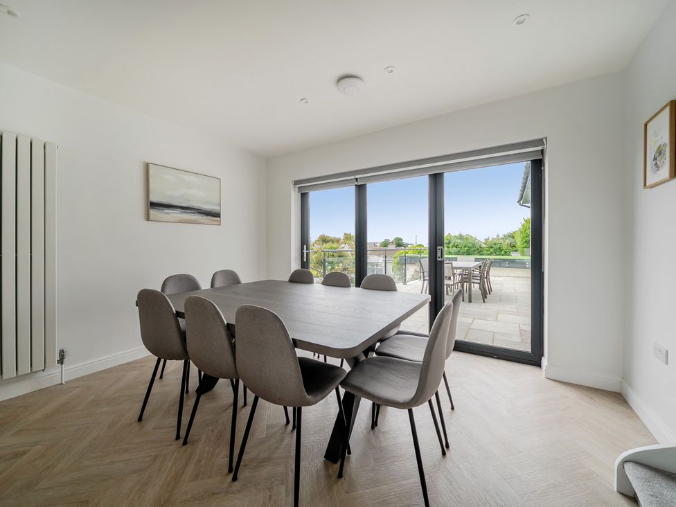 A dining room with a table and chairs at Seaddler in Trearddur Bay