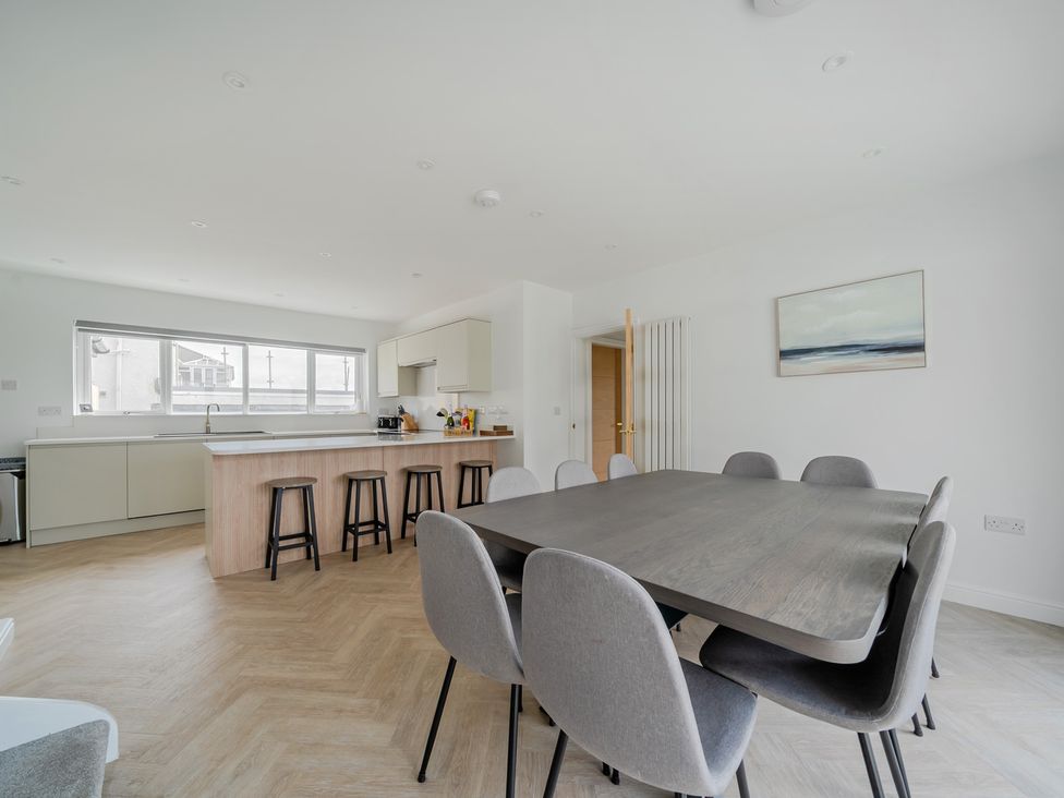 A kitchen with dining table and chairs at Seaddler in Trearddur Bay