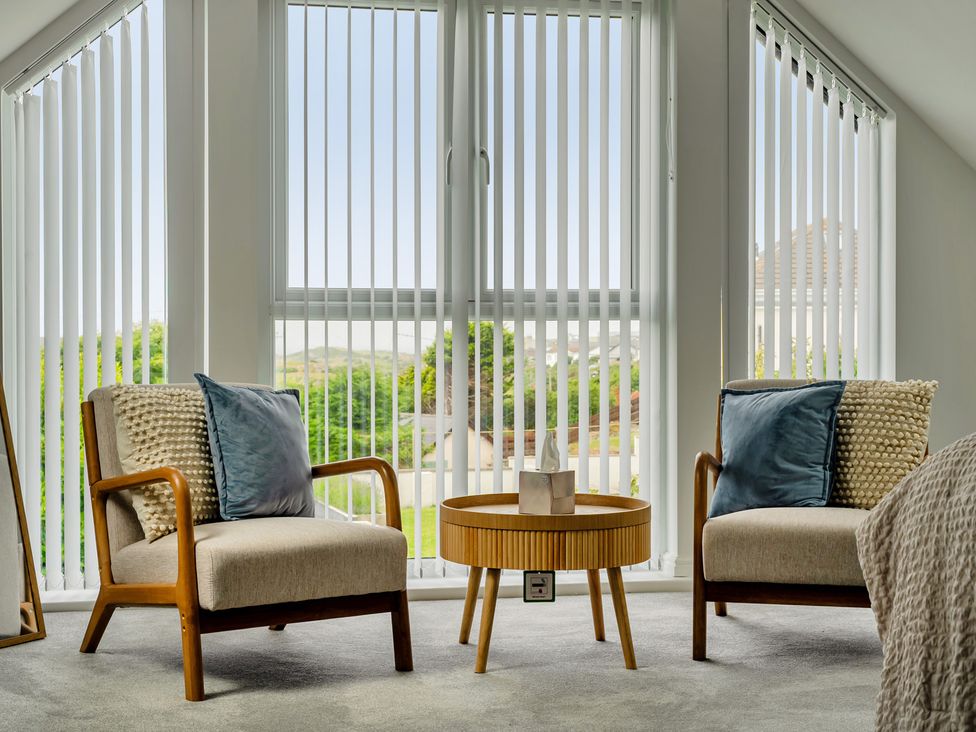 A living room with two chairs and a coffee table at Seaddler in Trearddur Bay