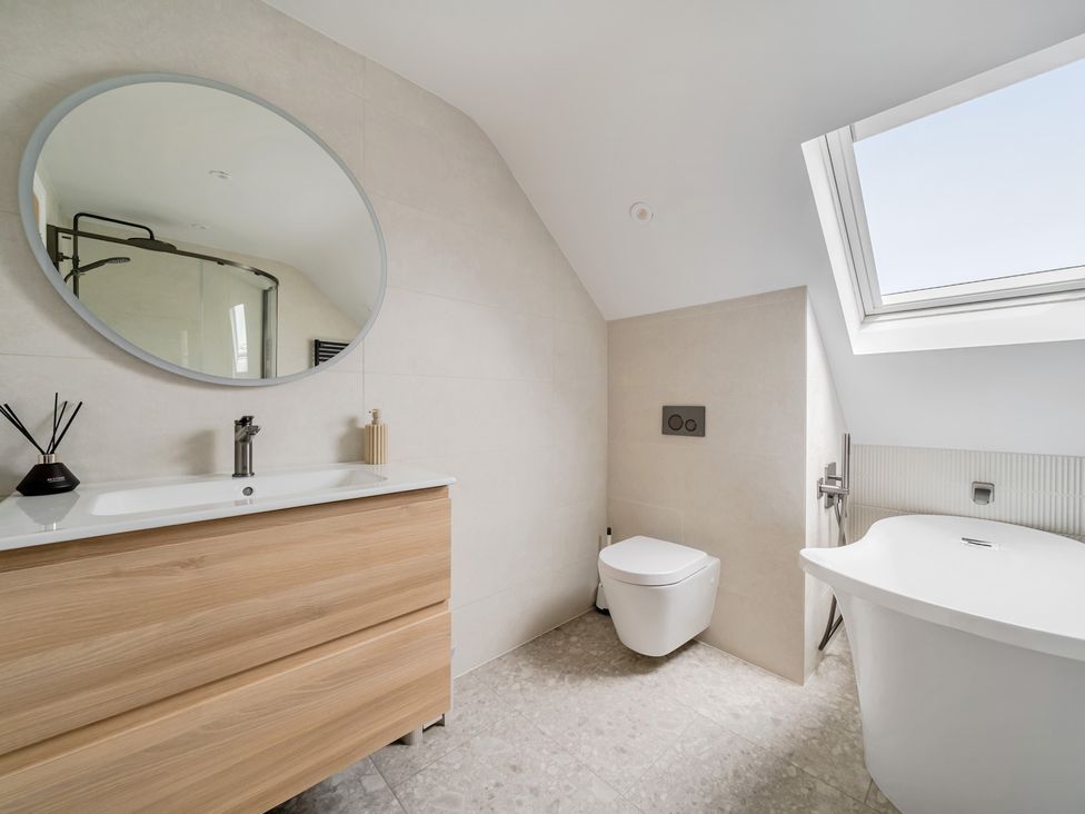 A bathroom with a bathtub and vanity at Seaddler in Trearddur Bay