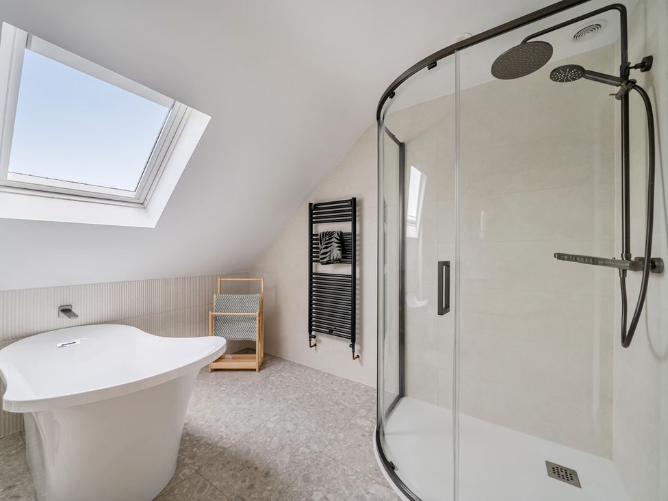 A bathroom with a bathtub and shower at Seaddler in Trearddur Bay