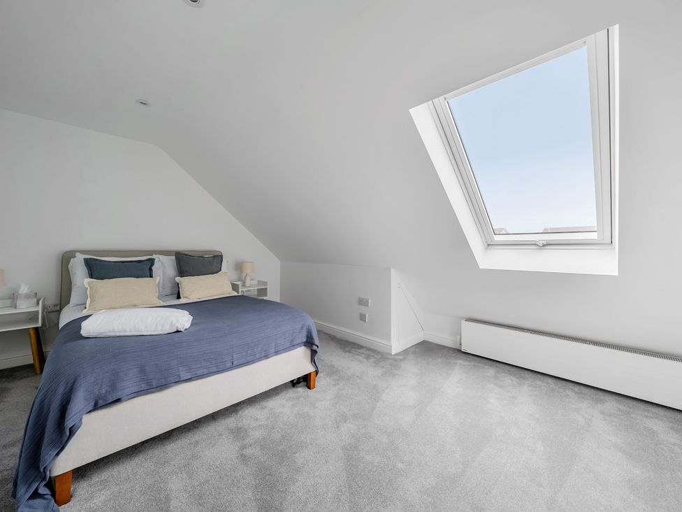 A bedroom with a bed and window at Seaddler in Trearddur Bay
