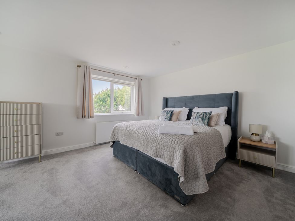 A bedroom with a bed and dresser at Seaddler in Trearddur Bay