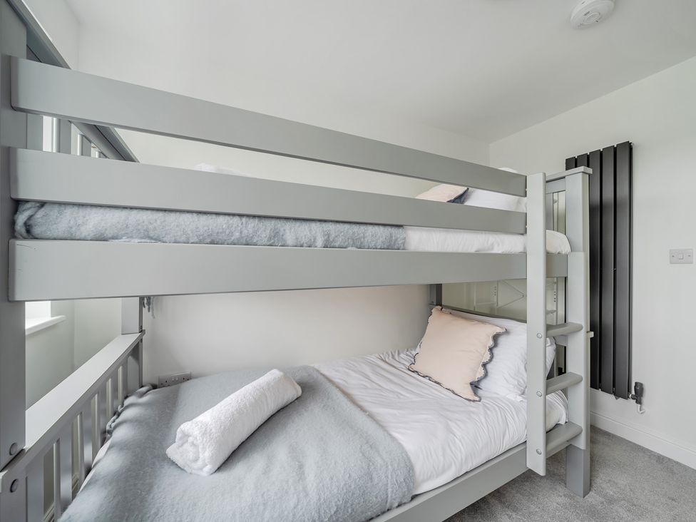 A bunk bed with bedding in a bedroom at Seaddler in Trearddur Bay