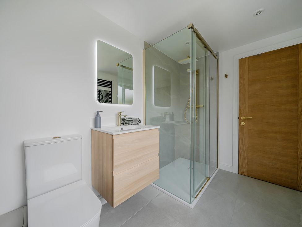 A bathroom with a shower and a cabinet at Seaddler in Trearddur Bay